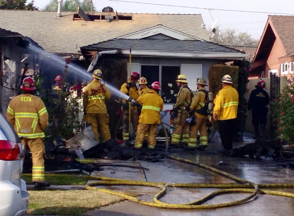 Orange County Fire Authority firefighters pour water on a house fire on Wednesday, Jan. 8, 2013 in Santa Ana, Calif. Two people were killed and four others were injured in an early morning fire Wednesday at a group home for developmentally disabled adult women in California, authorities said. (AP Photo/Gillian Flaccus)