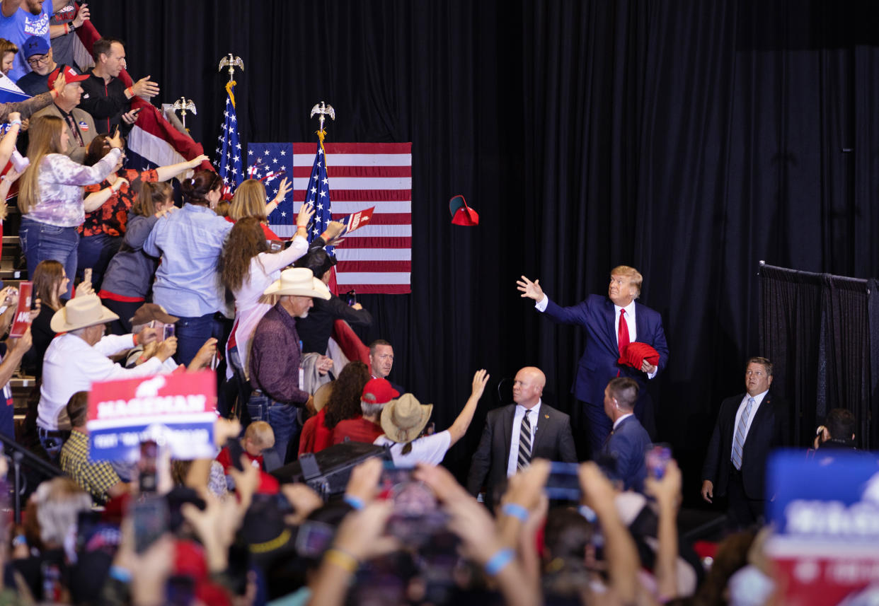 Former President Donald Trump tosses red MAGA hats to the crowd during a rally May 28, 2022 at the Ford Event Center in Casper, Wyo. (David Stubbs for NBC News)