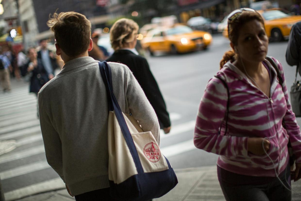 <span>A person carries a Trader Joe's tote in New York City.</span><span>Photograph: Robert Nickelsberg/Alamy</span>