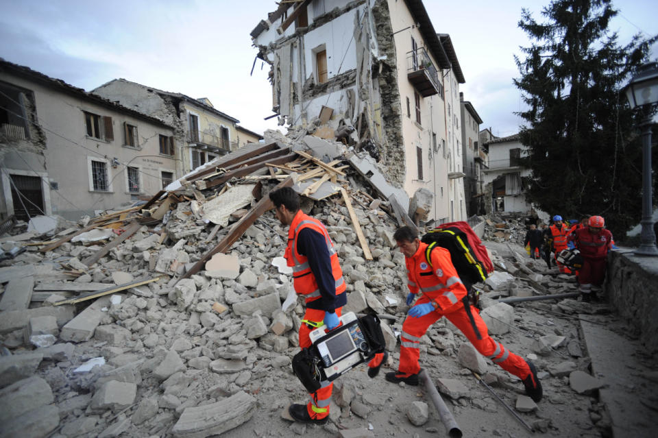 Rettungskräfte auf den Trümmern eines eingestürzten Hauses in Arcuata del Tronto. Zivilschutz, Feuerwehr, das Rote Kreuz und viele weitere Institutionen helfen nach der Naturkatastrophe. So engagiert, dass die Helfer laut “FAZ” keine Zeit für eine Mittagspause haben. Verständlich, denn … (Bild-Copyright: AP Photo/Sandro Perozzi)