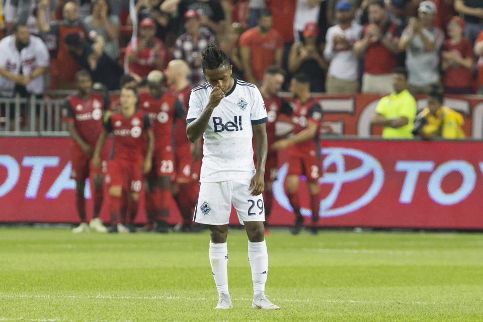 Vancouver Whitecaps' Yordi Reyna reacts as Toronto FC's Sebastian Giovinco, rear left, and teammates celebrate a goal during the first half in the second leg of the Canadian soccer championship final, Wednesday, Aug. 15, 2018, in Toronto. (Chris Young/The Canadian Press via AP)