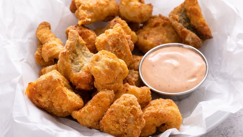 Remoulade sauce beside a basket of fried catfish nuggets