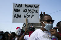 Fotografía del 12 de febrero de 2020 de un manifestante con un cartel que dice en criollo “Abajo con el secuestro, abajo con la violación, abajo con el robo”, durante una protesta contra la violencia en Puerto Príncipe, Haití. (AP Foto/Dieu Nalio Chery)