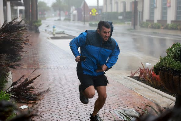 Brent Shaynore runs to a sheltered spot through the wind and rain from Hurricane Ian on September 28, 2022, in Sarasota, Florida.