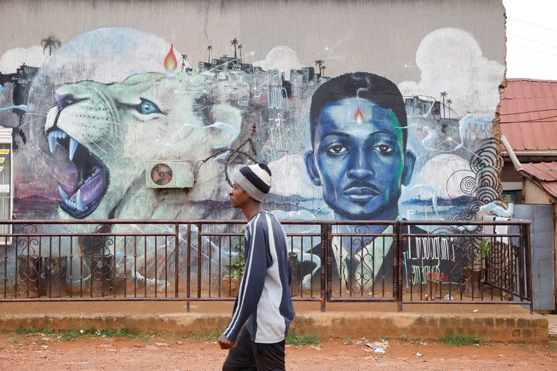 A man walks past a graffiti of Ugandan opposition presidential candidate Robert Kyagulanyi, also known as Bobi Wine, in Kampala