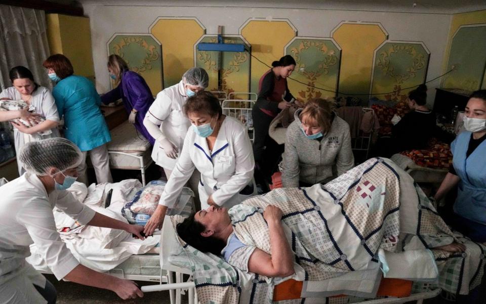 Medical workers move a patient in a basement of a maternity hospital converted into a medical ward in Mariupol, - Evgeniy Maloletka /AP
