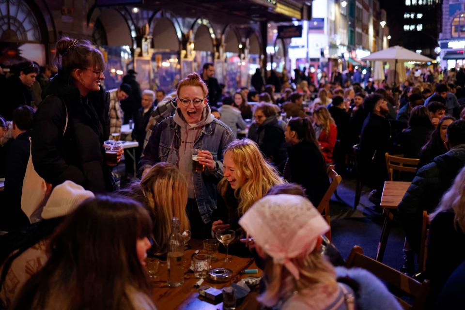 Customers enjoy drinks at tables outside the pubs and bars in the Soho area of London, on April 12, 2021 as coronavirus restrictions are eased across the country in step two of the government's roadmap out of England's third national lockdown. - Britons on Monday toasted a significant easing of coronavirus restrictions, with early morning pints -- and much-needed haircuts -- as the country took a tentative step towards the resumption of normal life. Businesses including non-essential retail, gyms, salons and outdoor hospitality were all able to open for the first time in months in the second step of the government's roadmap out of lockdown. (Photo by Tolga Akmen / AFP) (Photo by TOLGA AKMEN/AFP via Getty Images)