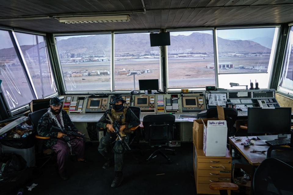 Taliban fighters sit at controller's stations in the Kabul airport's control tower