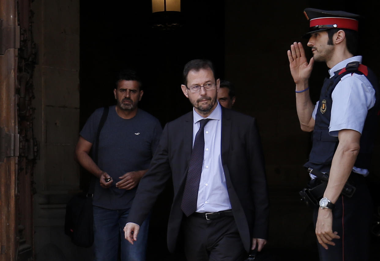 A Mosso D’Esquadra (Catalan regional police officer) salutes Spanish anti-corruption prosecutor José Grinda, center, as he leaves the Generalitat de Catalunya (Catalan government) in Barcelona in 2017. (Photo: Pau Barrena/AFP/Getty Images)