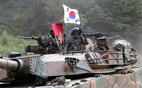 South Korean army soldiers ride a K-1 tank during a military exercise in Paju - Credit: Ahn Young-joon/AP