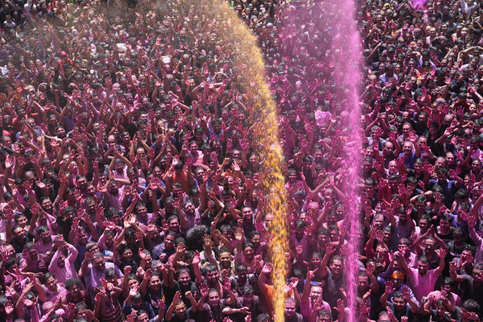 FILE - Devotees cheer as colored powder and water is sprayed on them during celebrations marking Holi, the Hindu festival of colors, at the Kalupur Swaminarayan temple in Ahmedabad, India, Friday, March 18, 2022. The nones in India come from an array of belief backgrounds, including Hindu, Muslim and Sikh. The surge of Hindu nationalism has shrunk the space for the nones over the last decade, activists say. (AP Photo/Ajit Solanki, File)