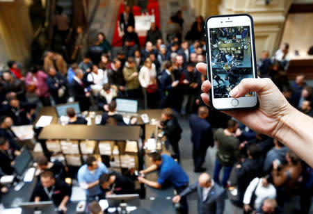 FILE PHOTO: A visitor takes pictures as customers gather at a store selling Apple products during the launch of the new iPhone 7 sales at the State Department Store, GUM, in central Moscow, Russia September 23, 2016. REUTERS/Sergei Karpukhin/File Photo