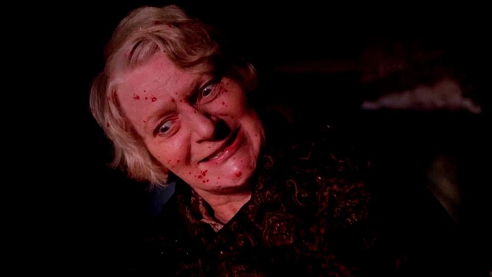 Sheila Keith, with terrifying crazed glee in her eyes and blood on her face, in the Pete Walker horror movie Frightmare.