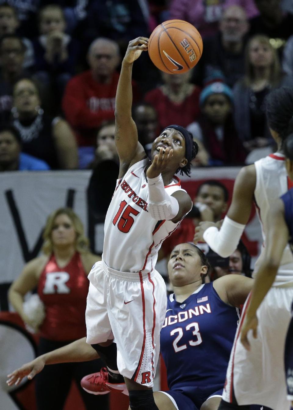 Rutgers guard Syessence Davis (15) takes a shot over her shoulder Connecticut defenders forward Kaleena Mosqueda-Lewis (23) falls during the first half of an NCAA college basketball game Sunday, Jan. 19, 2014, in Piscataway, N.J. (AP Photo/Mel Evans)