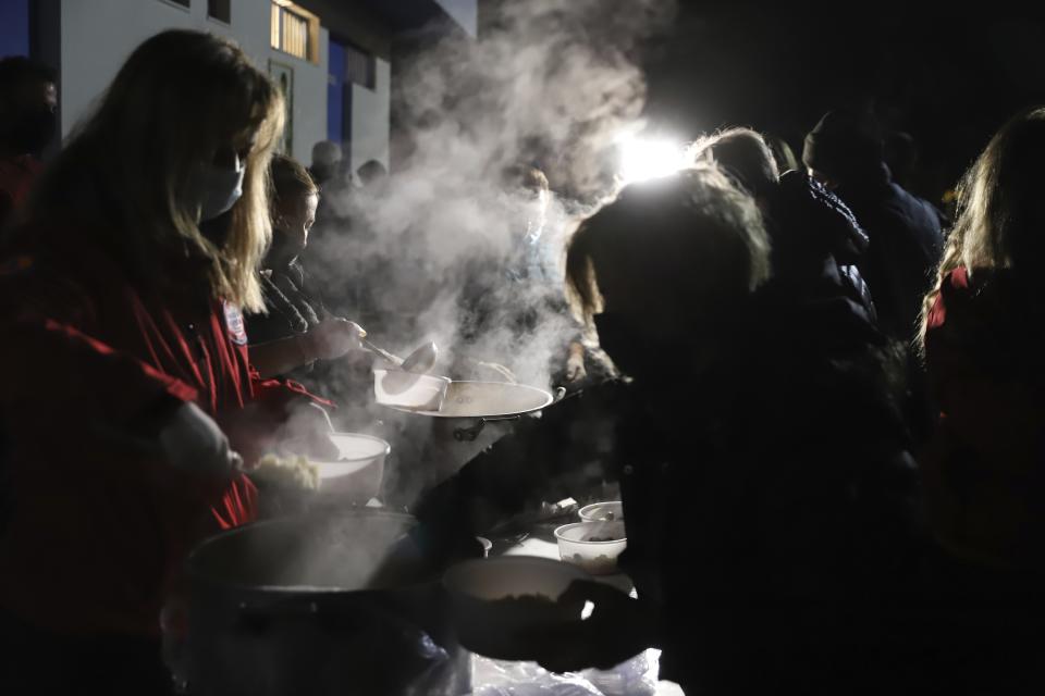 Red Cross distribute food to local residents after an earthquake in Damasi village, central Greece, Wednesday, March 3, 2021. An earthquake with a preliminary magnitude of at least 6.0 struck central Greece Wednesday and was also felt in neighboring Albania and North Macedonia, and as far as Kosovo and Montenegro. (AP Photo/Vaggelis Kousioras)