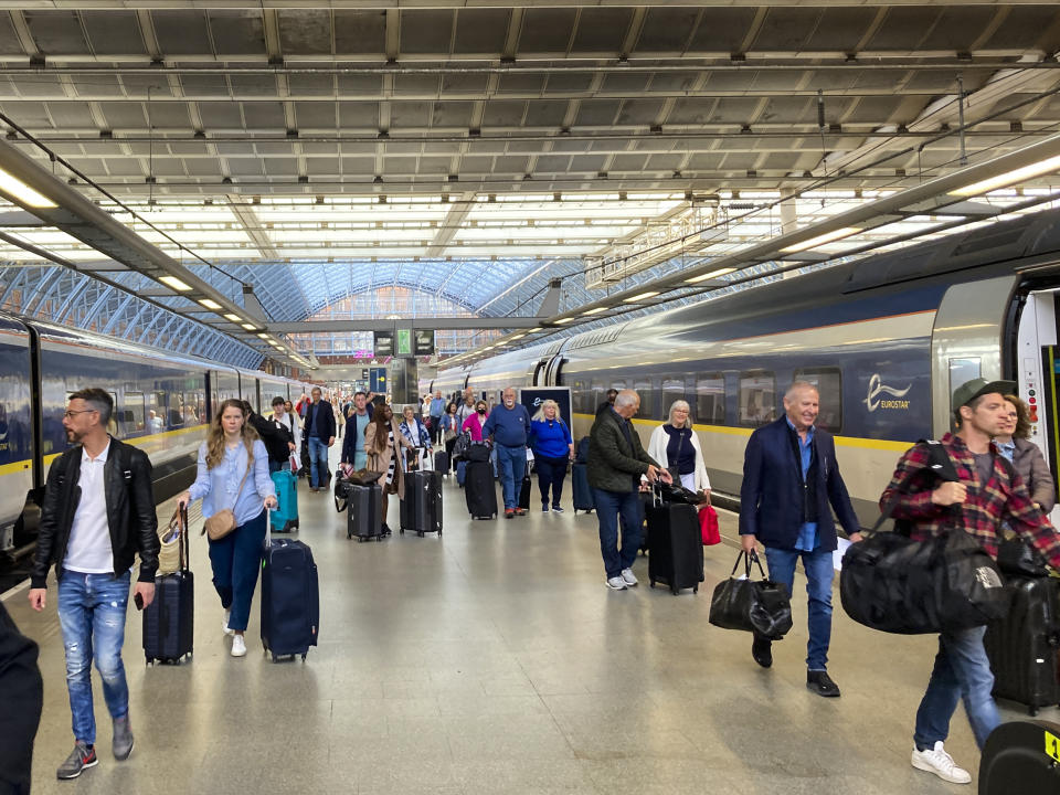 Travelers at St. Pancras International train station board the high speed Eurostar train to Paris, in London, Saturday, May 21, 2022. The World Economic Forum is encouraging European attendees to come to its exclusive gathering in the Swiss Alps by train. Its part of efforts to burnish the sustainability credentials for an event in Davos that conjures up up images of government leaders, billionaire elites and corporate titans jetting in on carbon-spewing private planes. (AP Photo/Kelvin Chan)