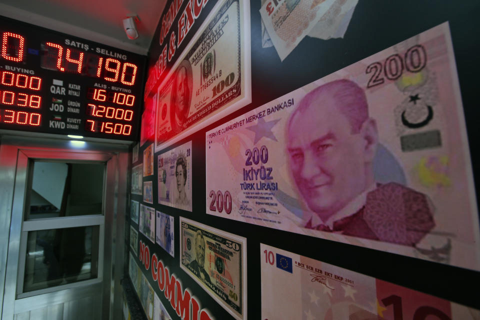 CORRECTING CAPTION BYLINE TO LEFTERIS PITARAKIS - An oversized copy of a 200 Turkish lira banknote, featuring a photo of modern Turkey's founder Mustafa Kemal Ataturk decorates a currency exchange shop in Istanbul. The Turkish lira has nosedived in value in the past week over concerns about Turkey's President Recep Tayyip Erdogan's economic policies and after the United States slapped sanctions on Turkey angered by the continued detention of an American pastor. (AP Photo/Lefteris Pitarakis)