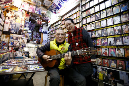 Kazuhiko Kobayashi, 80, and his wife Mieko Kobayashi, 73, pose for a photograph at their music shop named Ameyoko Rhythm, specialised for Enka, traditional Japanese popular ballad, in Tokyo's Ameyoko shopping district, Japan, February 8, 2018. "I met her in 1963, 55 years ago. She was a classmate of my younger sister. One day she came over to my house and I took a shine to her because she was so charming. Since that day on, I called her every day. In the beginning, she did not seem to be interested in me, but I conveyed my passion to her. On our first date, I waited at a meeting place for an hour. It turned out she had been advised by her mother and older sister to be late for an hour to see whether I was serious about her. My feelings got through to her, and we married on October 15, 1964, five days after the opening ceremony of the Tokyo Olympics. Fifty four years have passed since then. We see each other most of the time, both at home and at this shop, which has been in business for about 50 years, but I still find her charming every day!" said Kazuhiko. REUTERS/Toru Hanai