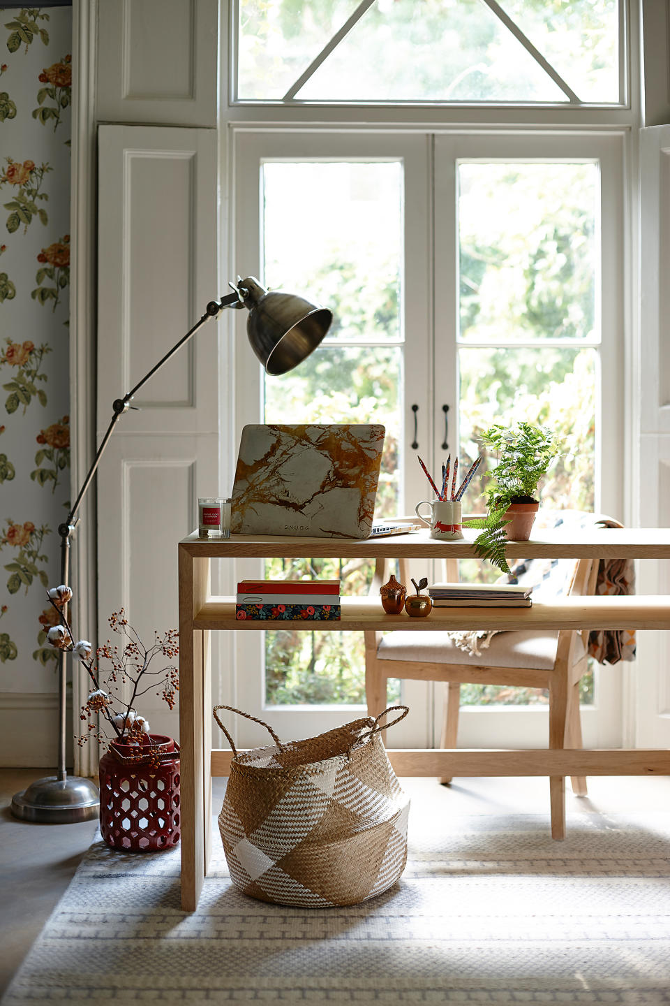 home office laptop on table with freestanding light in front of patio doors