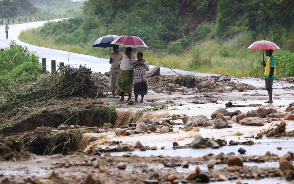 Locals in the Chiradzulu district look at the damage on a road after mudslides and rockfalls in the area caused by the aftermath of Cyclone Freddy in Blantyre, Malawi - ESA ALEXANDER/REUTERS