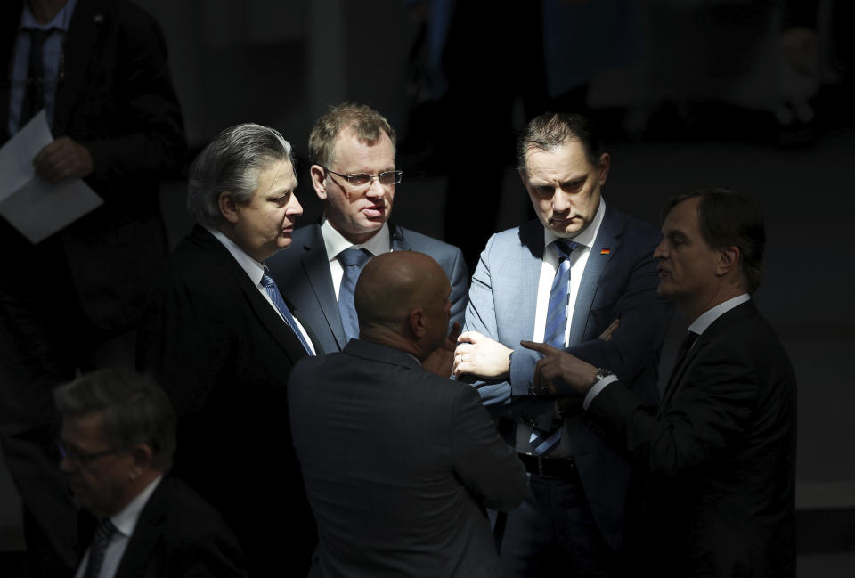 FILE - In this Wednesday, March 25, 2020 file photo Tino Chrupalla, member of the party's board, and other lawmaker of the AfD (Alternative for Germany) party talk prior to a meeting of the German federal parliament, Bundestag, at the Reichstag building in Berlin, Germany. Migration is a side issue in this year's German election campaign, but that hasn't stopped the country's biggest far-right party from trying to play it up. (AP Photo/Michael Sohn)