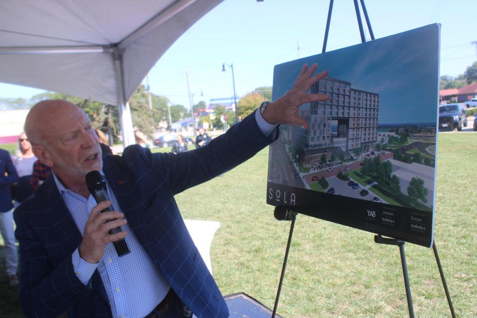 During a groundbreaking Friday in Michigan City, developer Alan Schachtman of Farpoint Development points to an artist's rendering of two mixed-use high rises that are slated to be built near the lakefront in the next two years.