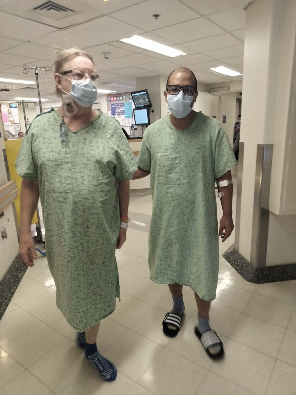 Joseph Reek, left, and his husband, Nilson DaSilva, wander the hallways as part of a post-operative exercise program three days after kidney-transplant surgery.