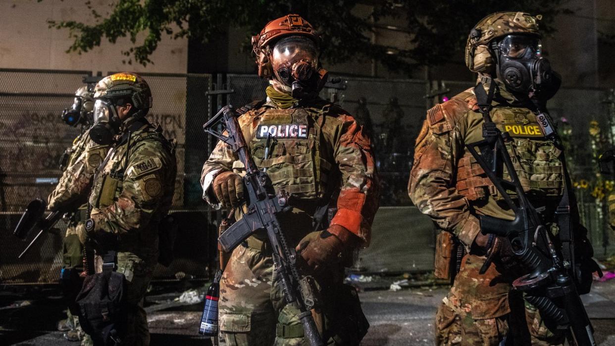 US-Bundespolizisten stehen mit der Hand an der Waffe am Rande von Protesten in Portland.