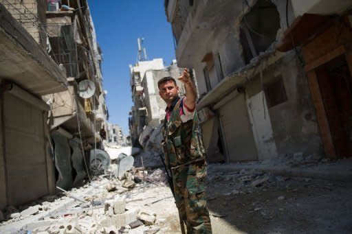 A Syrian rebel stands in a heavily damaged street in the Salaheddin district of the northern city of Aleppo. Grisly footage has emerged appearing to show rebels in the Aleppo area callously throwing bodies off a post office building, while another video showed a man, blindfolded and bound, as his throat was savagely cut