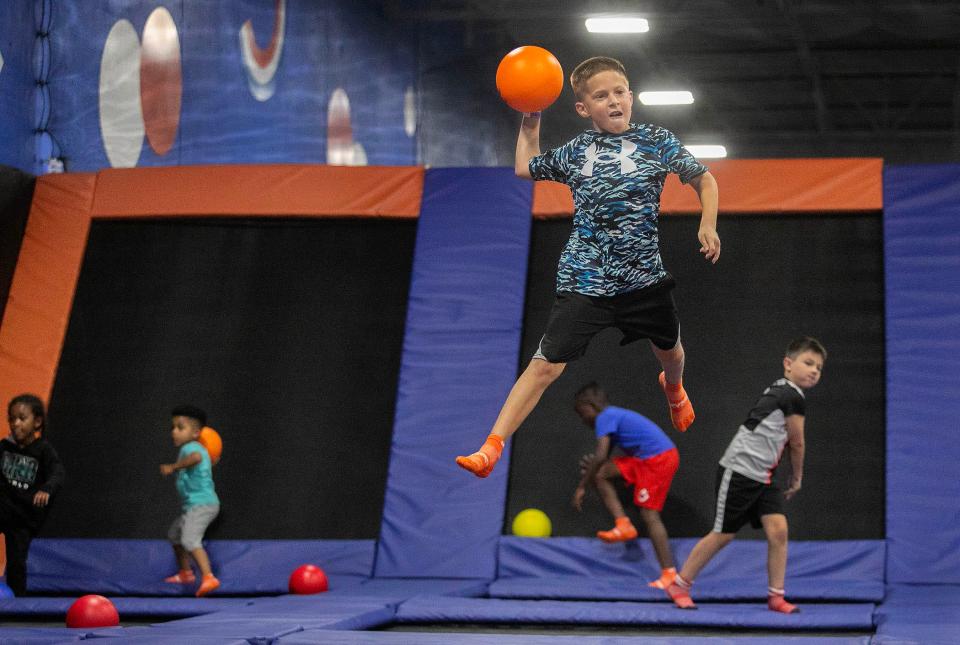 Tanner Rinaman, 10, of Lantana, goes airborne during a dodge ball clash at Sky Zone Trampoline Park grand opening Saturday May 18, 2024 in Boynton Beach.