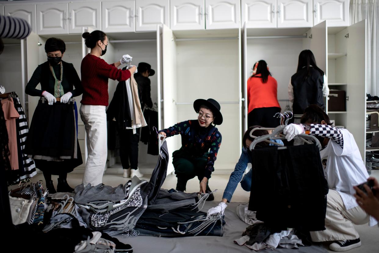 Bian Lichun (C), founder of the Liucundao Business School, sorting luxury clothes with students during a home organising class in Beijing.