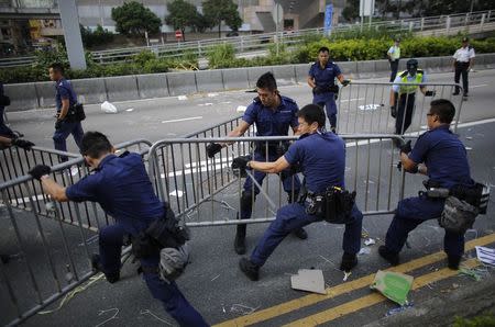 Police remove barricades erected by pro-democracy protesters at the main protest site in Admiralty in Hong Kong October 13, 2014. REUTERS/Carlos Barria