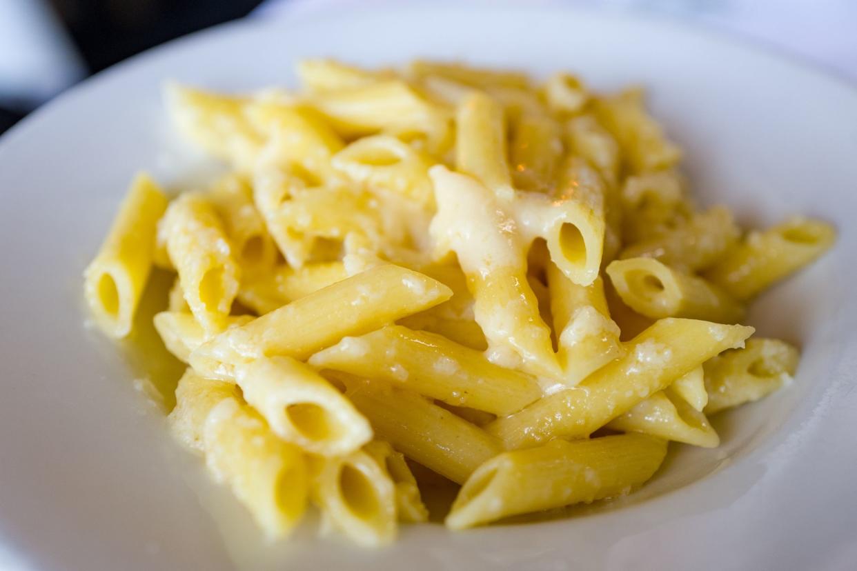 Close-up of penne pasta in a white bowl with melted Parmesan cheese and butter, April 11, 2019