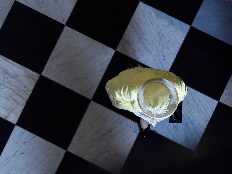 Queen Elizabeth in St. Paul's Cathedral in London walking on a checkered floor like a chess piece