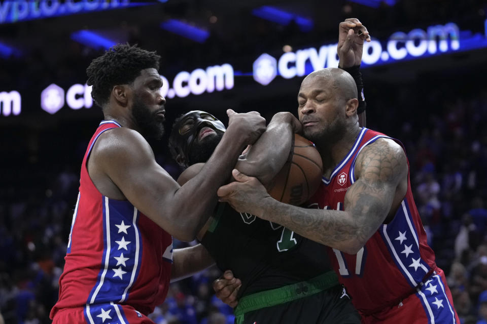 Philadelphia 76ers' Joel Embiid, left, and P.J. Tucker, right, battle for the ball with Boston Celtics' Jaylen Brown, center, during the second half of Game 3 in an NBA basketball Eastern Conference semifinals playoff series, Friday, May 5, 2023, in Philadelphia. (AP Photo/Matt Slocum)