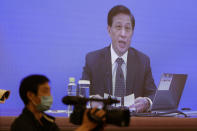 Zhang Yesui, a spokesman for the National People's Congress, broadcast on a screen at a media center during a press conference on the eve of the annual legislature opening session in Beijing on Thursday, May 21, 2020. The holding of the "two sessions," as the annual meetings are known, is a further sign of what the ruling Communist Party says is its success in bringing the outbreak under control, though clusters of cases are still popping up in some parts of the country. (AP Photo/Mark Schiefelbein)