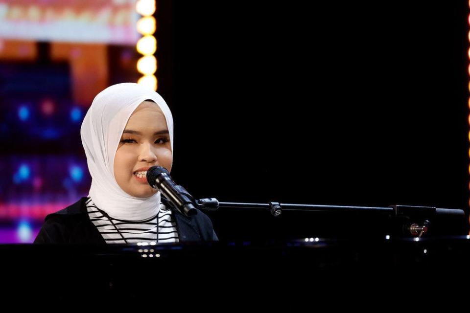 Teen singer Putri Ariani, pictured, got behind the piano for a pair of soulful performances on "AGT" Tuesday night, earning a Golden Buzzer from Simon Cowell.