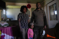 Married Haitian couple Pierre and Benita and their three-year-old, Chilean-born daughter Benita pose for a portrait inside their home in Santiago's Dignidad camp set up by migrants in Chile, Thursday, Sept. 30, 2021. Pierre, 37, says he feels caught in a vicious circle: he is unemployed and cannot get a job without a valid identity card, but he can’t get his card renewed without an employment contract. (AP Photo/Esteban Felix)