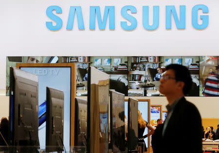 A journalist walks at the Samsung booth during a media preview day at the IFA consumer electronics fair in Berlin, September 5, 2013. REUTERS/Fabrizio Bensch/File Photo