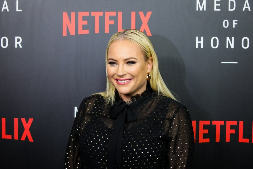 A blond woman in a high-necked black dress