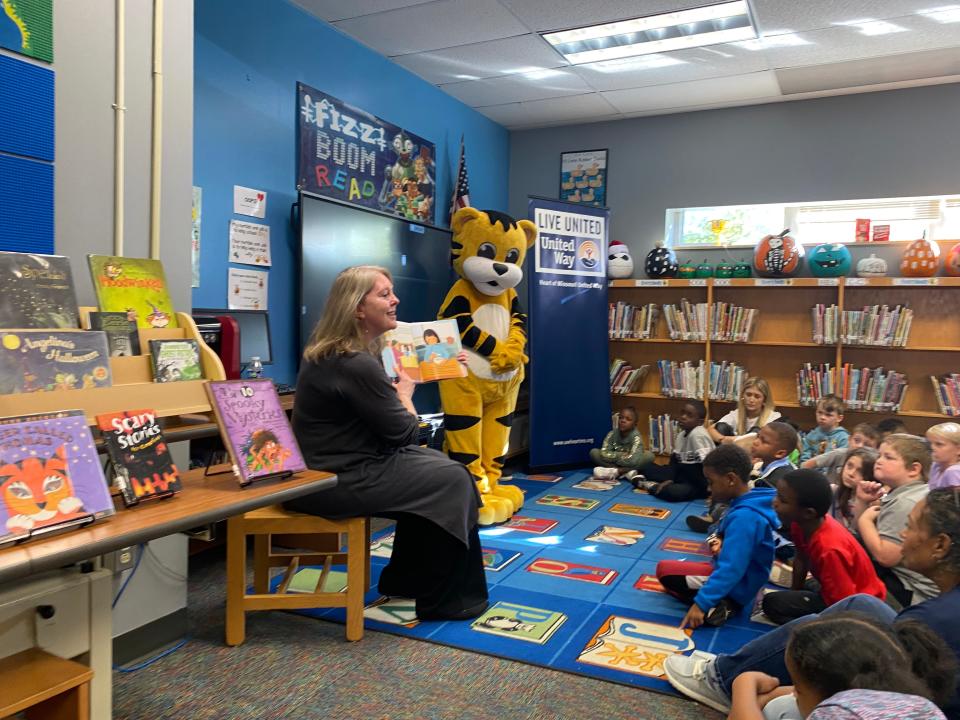 Katrina Lambrecht, chief operating officer for University of Missouri Health Care on Wednesday reads a book to first- and second-graders at Benton STEM Elementary School for a United Way Read Across America book giveaway event at the school.