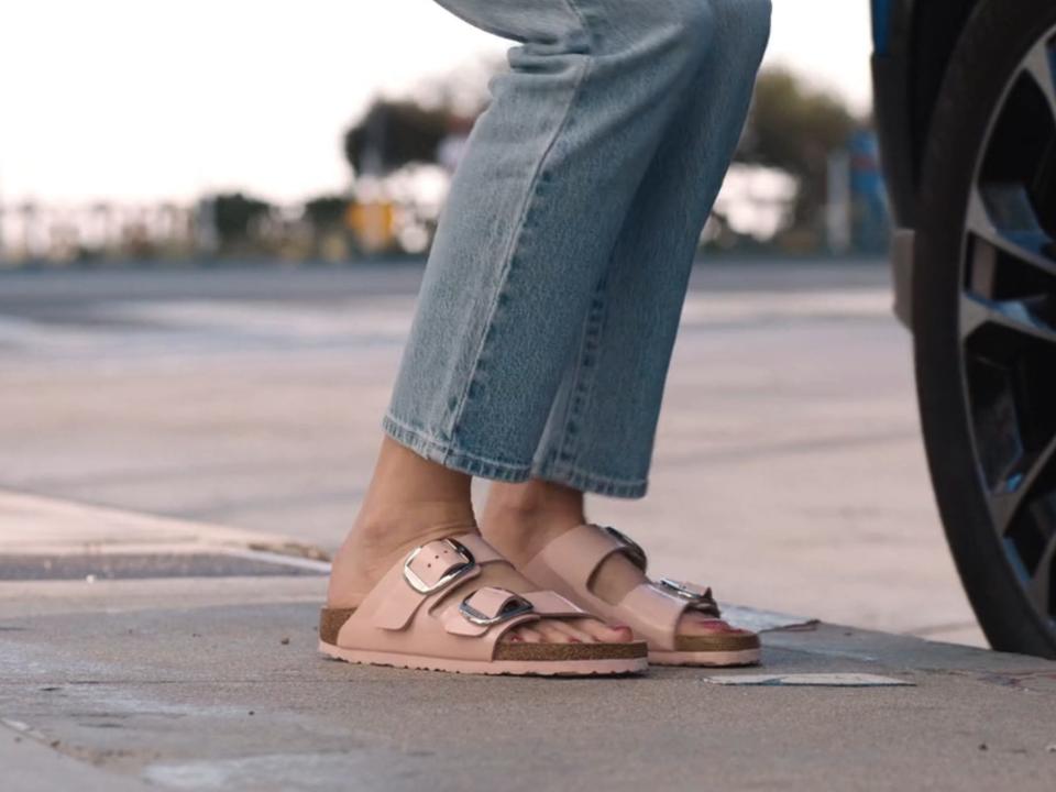 barbie's feet as she steps out of a car, she's wearing birkenstocks