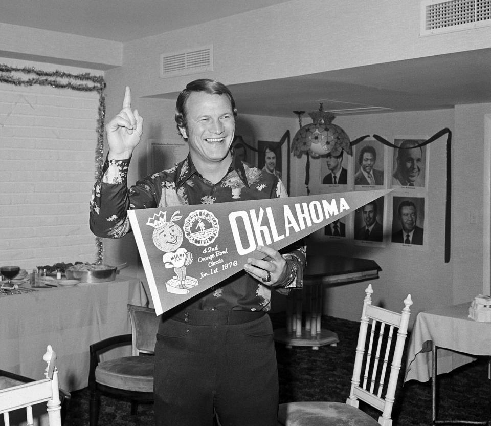 University of Oklahoma football coach Barry Switzer, who holds a banner and indicates his Sooners are Number 1, is seen after beating Michigan in the Orange Bowl game in Miami Beach, Jan. 2, 1976.  (AP Photo)