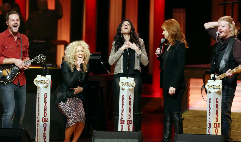 Opry member Reba McEntire, second from right, surprises Jimi Westbrook, left, Kimberly Schlapman, Karen Fairchild and Philip Sweet of Little Big Town with an invitation to join the Grand Ole Opry on Oct. 3, 2014.
