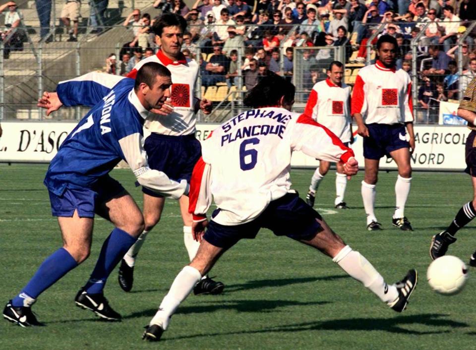 Former Manchester United's French soccer star Eric Cantona, left, beats Stephane Plancque, one of two brothers in whose testimonial he came out of retirement for, during the game in Lille, Northern France Sunday May 25, 1997.(AP Photo/Max Nash)