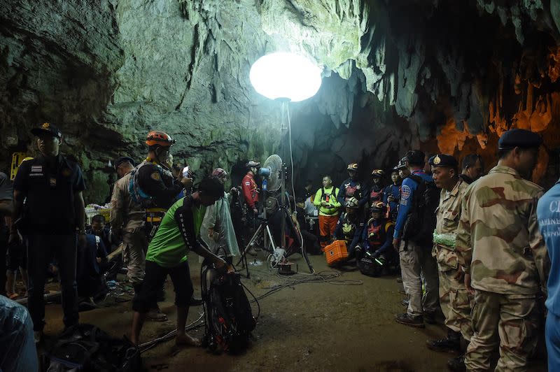 Thai rescue personnel are set up at the entrance of Tham Luang cave under floodlights. Source: Getty