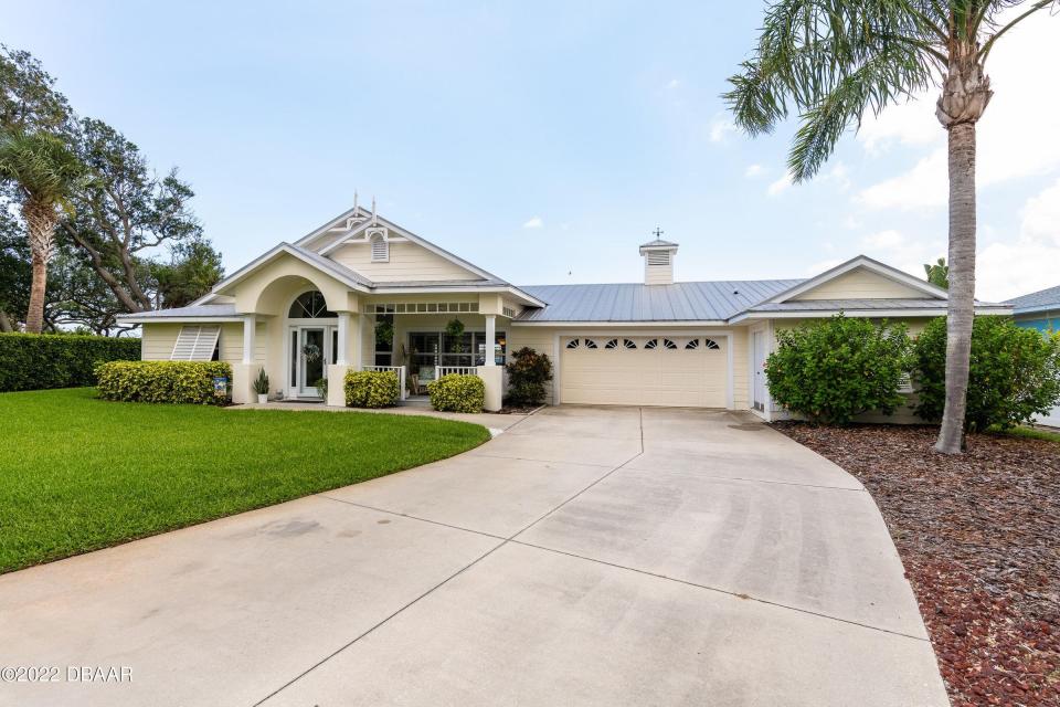 This stunning Ormond Beach home features fabulous outdoor living spaces overlooking the Intracoastal Waterway, a sparkling blue pool and a dock with boat house.
