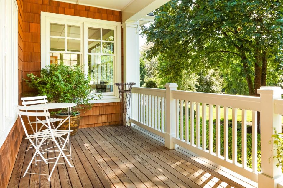 beautiful sunny front porch with bistro chairs and table to conserve space