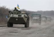 Members of the Ukrainian armed forces ride on an armoured personnel carrier near Artemivsk, eastern Ukraine, March 3, 2015. REUTERS/Gleb Garanich