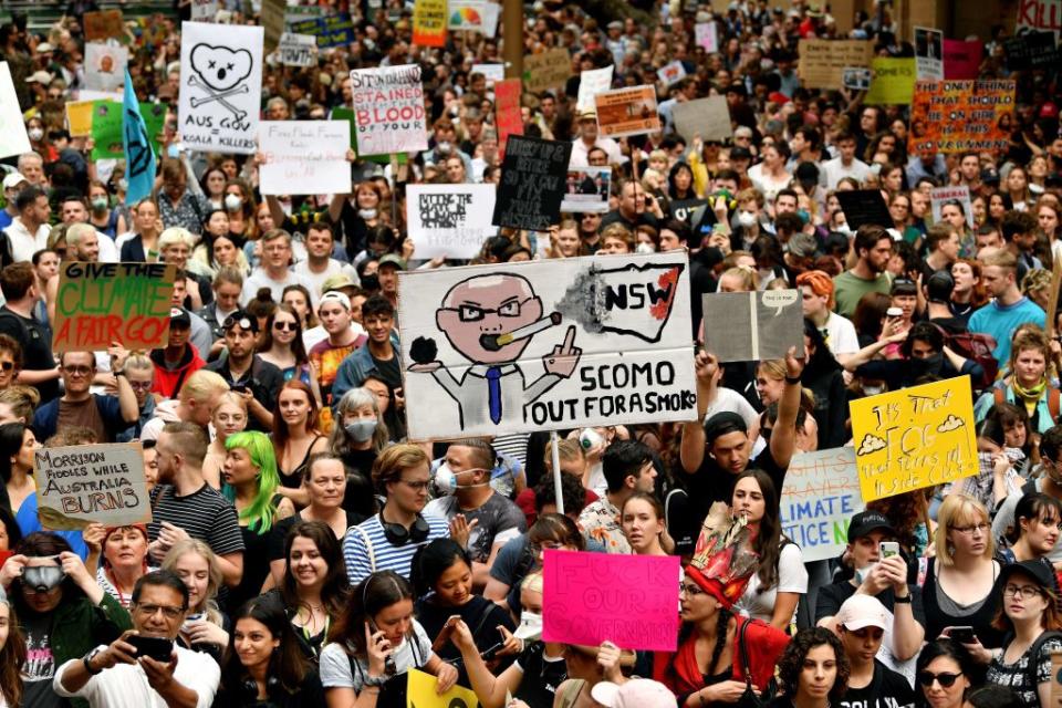 Demonstrators raise placards at a climate protest rally in Sydney on December 11, 2019. Source: Getty 